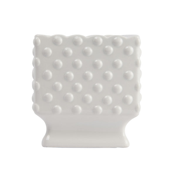 A white ceramic planter with a hobnail texture, scalloped edge, and polka dots.